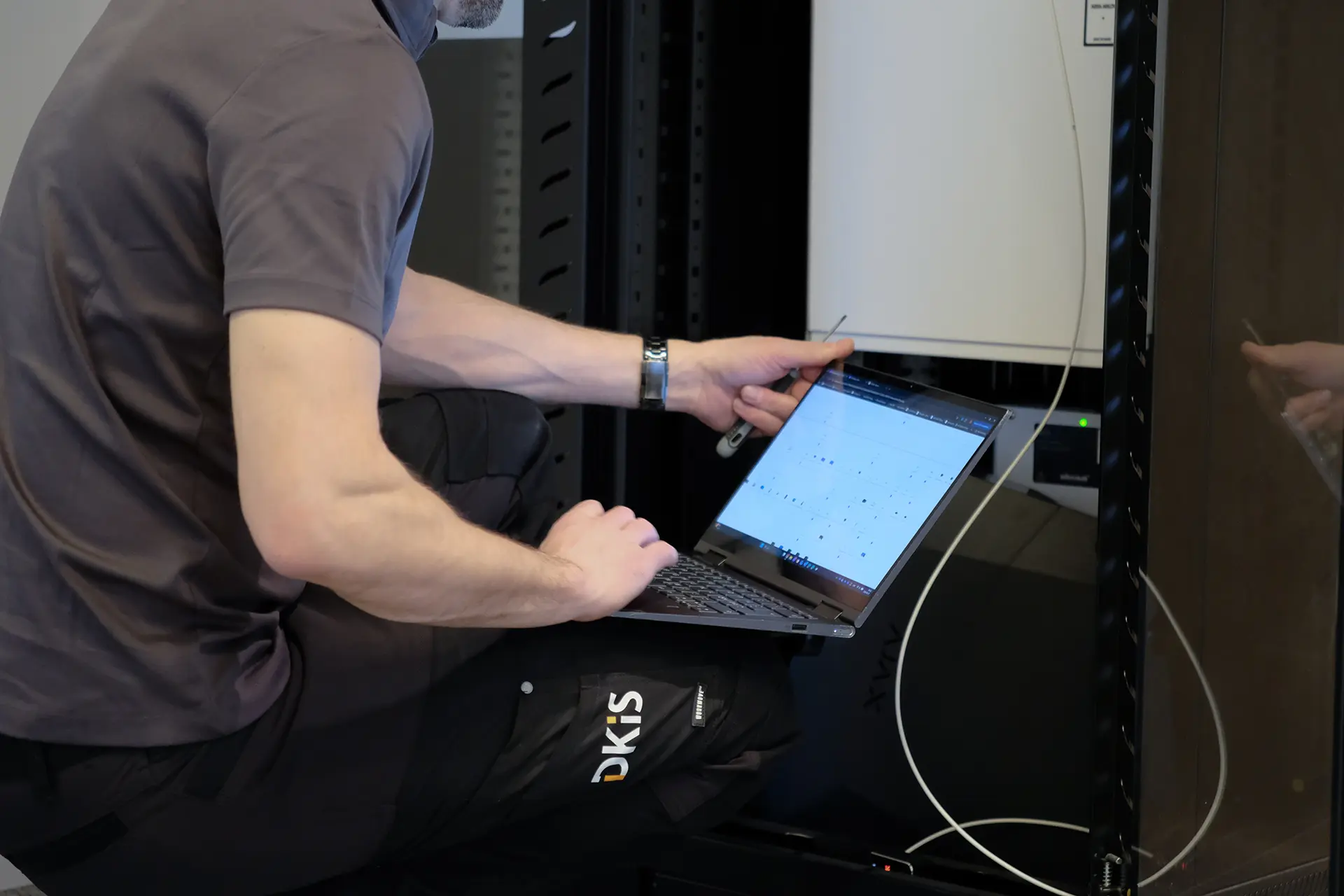 En tekniker arbetar med en bärbar dator framför ett serverskåp